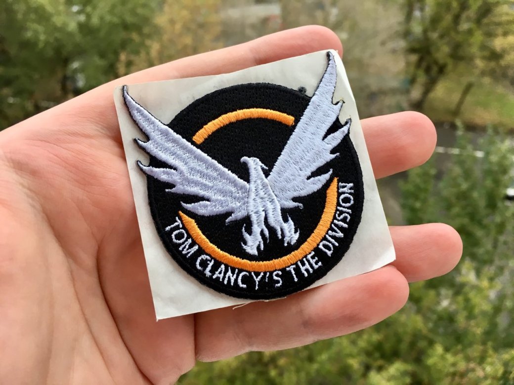 Всем поигравшим в The Division 2 на стенде дают вот такую нашивку. Она липкая. Очень. Можно даже приклеить ее на крышку ноутбука, и будет крепко держаться!